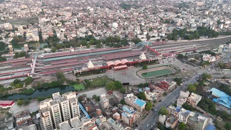 a sprawling railway terminal integrated into the urban fabric, surrounded by road networks, green patches, and high-rise apartments
