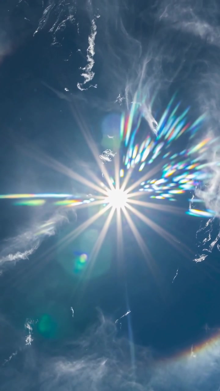 Video verticale: Telecamera che si sposta mostrando un bagliore solare, bagliori arcobaleno e nuvole cirri a mezzogiorno.