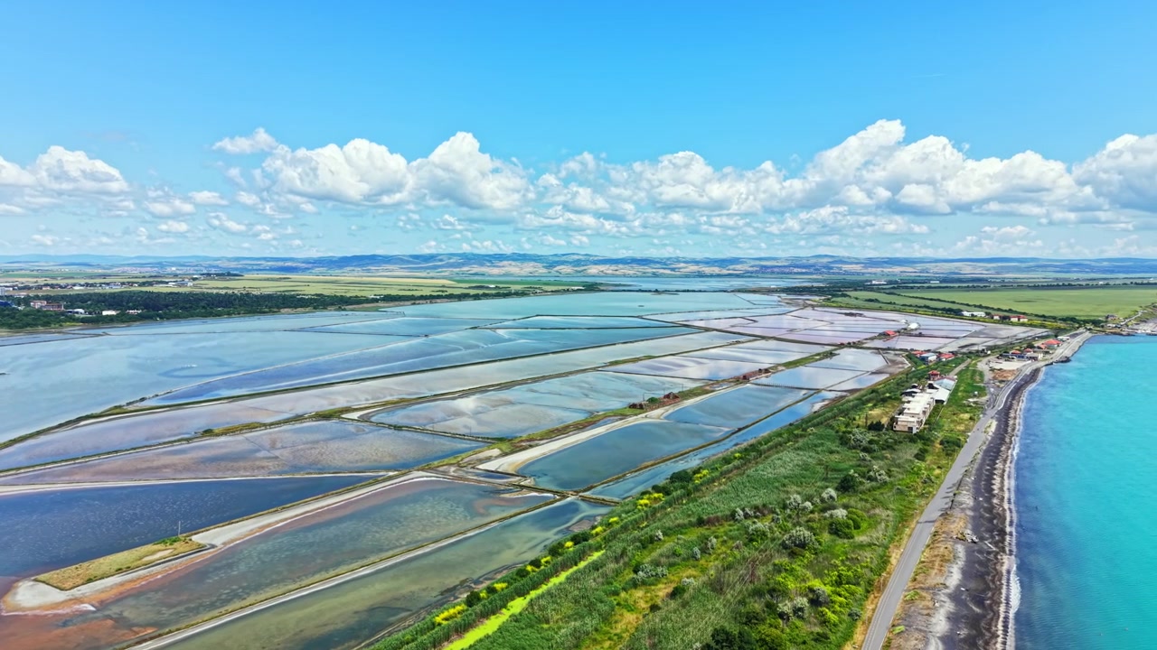 Utsikt over Burgas saltsletter og landskap under en blå himmel med skyer i det fjerne.