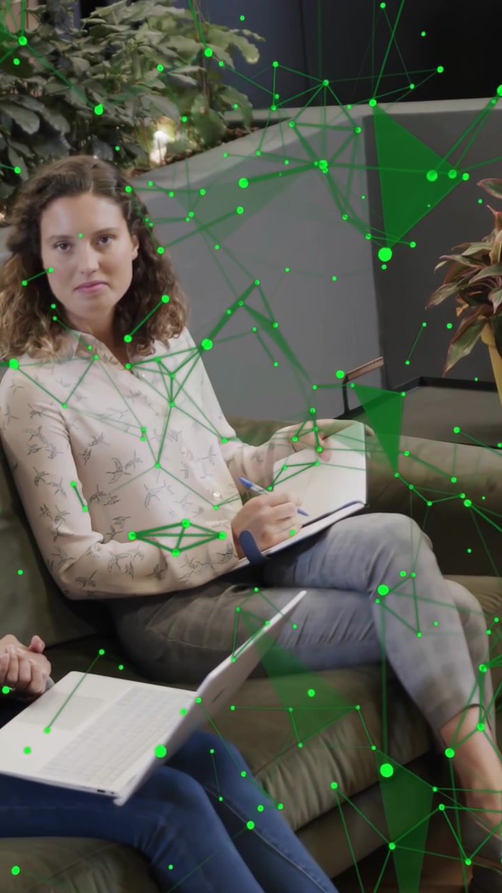 Video verticale: Donna che scrive su un quaderno a spirale in ufficio, la telecamera si sposta rivelando una sovrapposizione verde