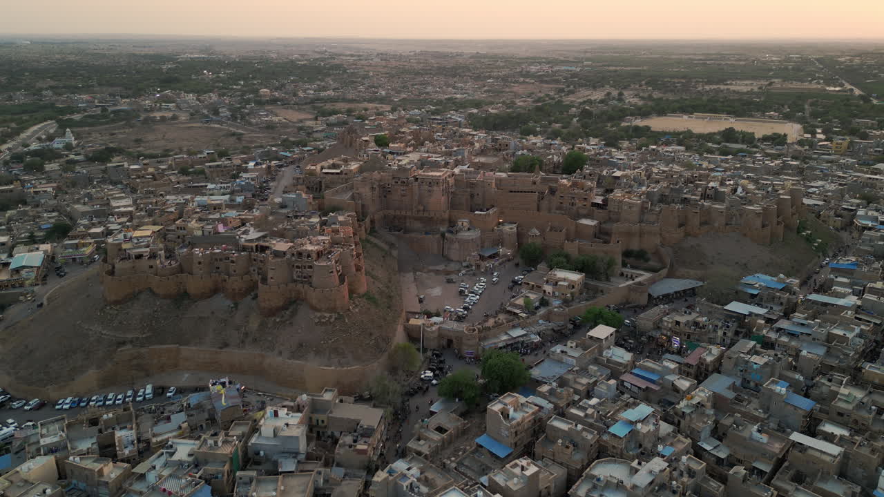 imágenes aéreas retroactivas de drones que muestran una impresionante puesta de sol sobre el fuerte de jaisalmer en rajasthan, india. el fuerte de piedra arenisca dorada se alza contra los vibrantes tonos del cielo