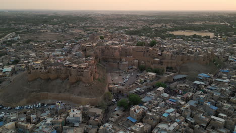 imágenes aéreas retroactivas de drones que muestran una impresionante puesta de sol sobre el fuerte de jaisalmer en rajasthan, india. el fuerte de piedra arenisca dorada se alza contra los vibrantes tonos del cielo