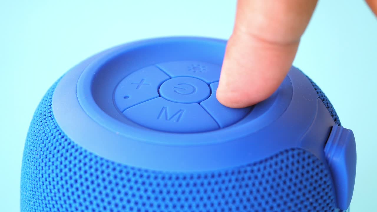 Closeup of a blue speaker with control buttons