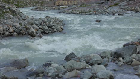 flowing river past small rock boulders near fellaria glacier