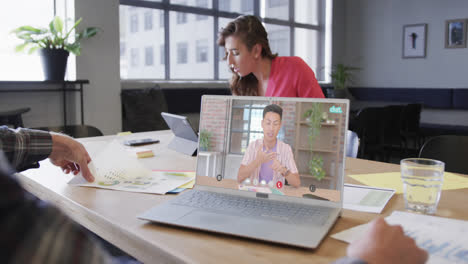 Caucasian-businessman-on-laptop-video-call-with-caucasian-male-colleague-on-screen