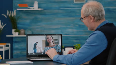 hombre mayor feliz saludando durante una videoconferencia con sobrinos usando una computadora portátil
