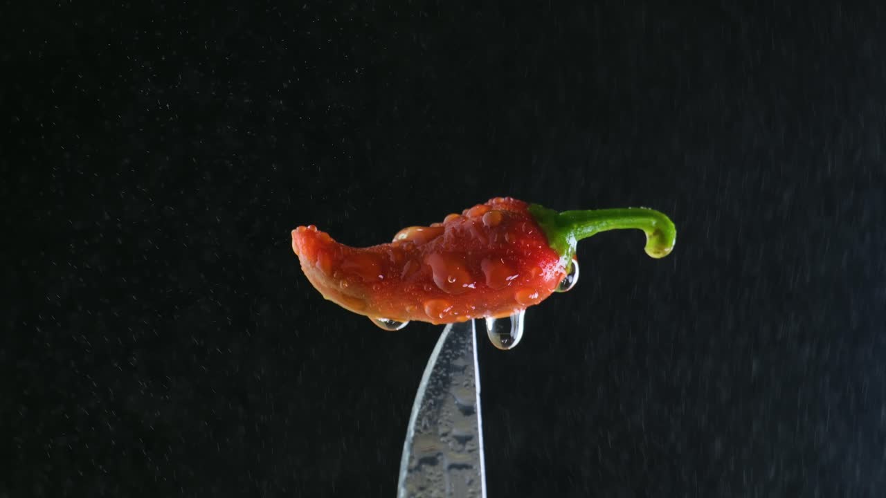 검은색 배경으로 칼에 은 칠리 고추