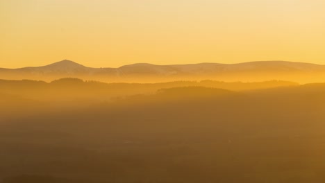 Landscape-time-lapse-of-Snezka,-Karkonosze-mountains,-during-a-foggy-yellow-sunset