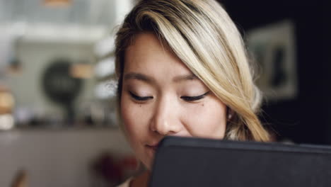 Asiatische-Frau-Benutzt-Digitales-Touchscreen-Display-Des-IPad-Tablets-Im-Café-Und-Trinkt-Kaffee