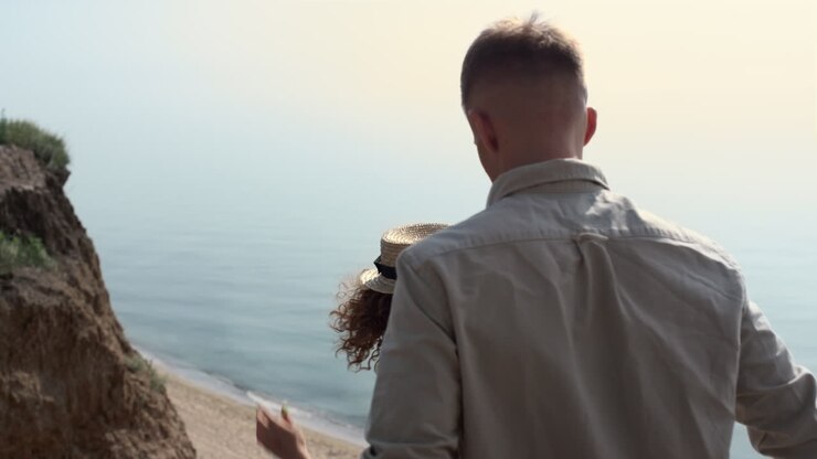 Coppia felice che scende le scale verso la spiaggia. Adorabile coppia che cammina sulla scalinata.