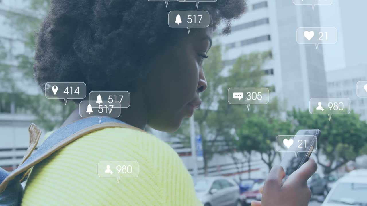 Animation of social media notifications over happy african american woman using smartphone in street