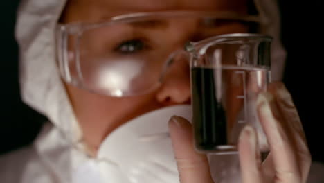 Scientist-examining-and-swirling-chemical-in-beaker