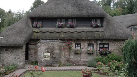 Rural-landscaped-thatched-cottage-countryside-garden-tourism-village-slow-pull-back