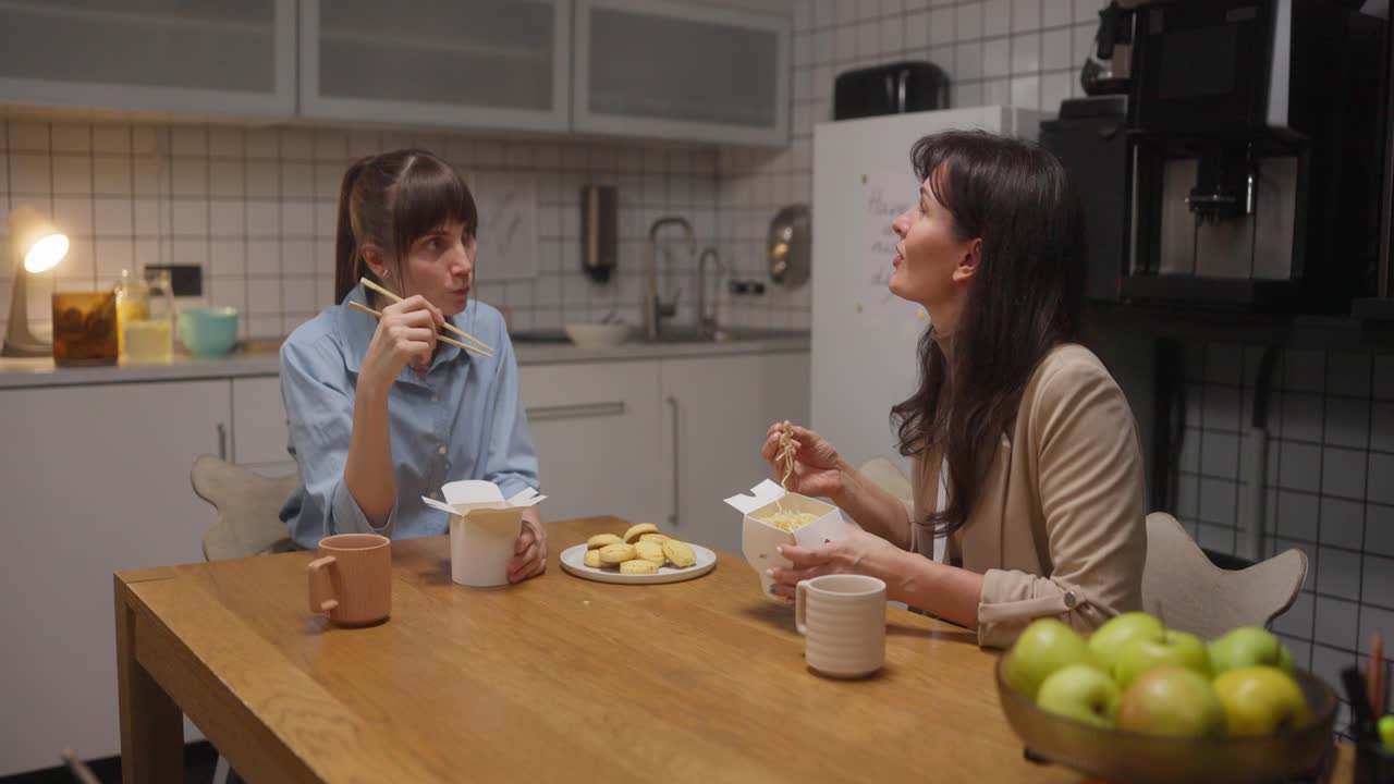 Two Women Eating Noodles in the Office Kitchen