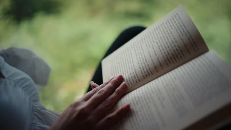 closeup shot of book while woman turning pages in a cabin