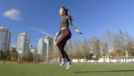 una joven atlética en forma entrenando saltando en el parque de la ciudad