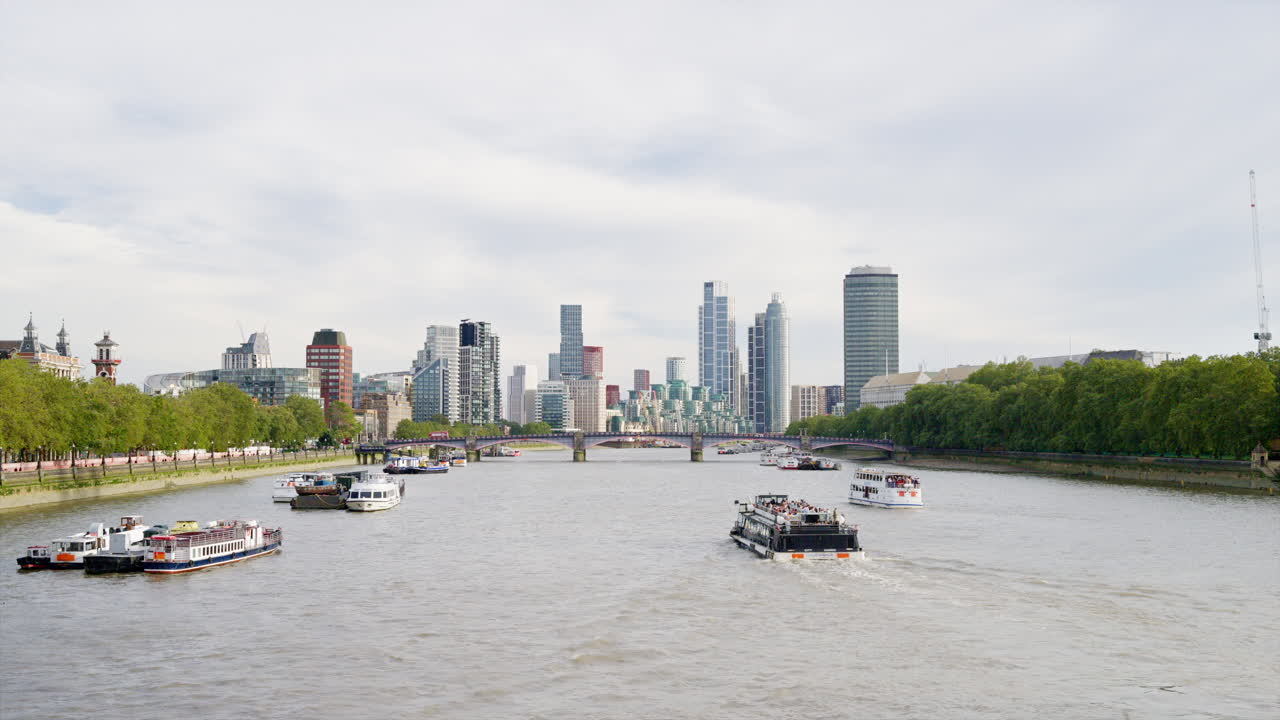 View of the Canary Wharf district in London, United Kingdom. View from the Westminster bridge, Thames river with floating boats