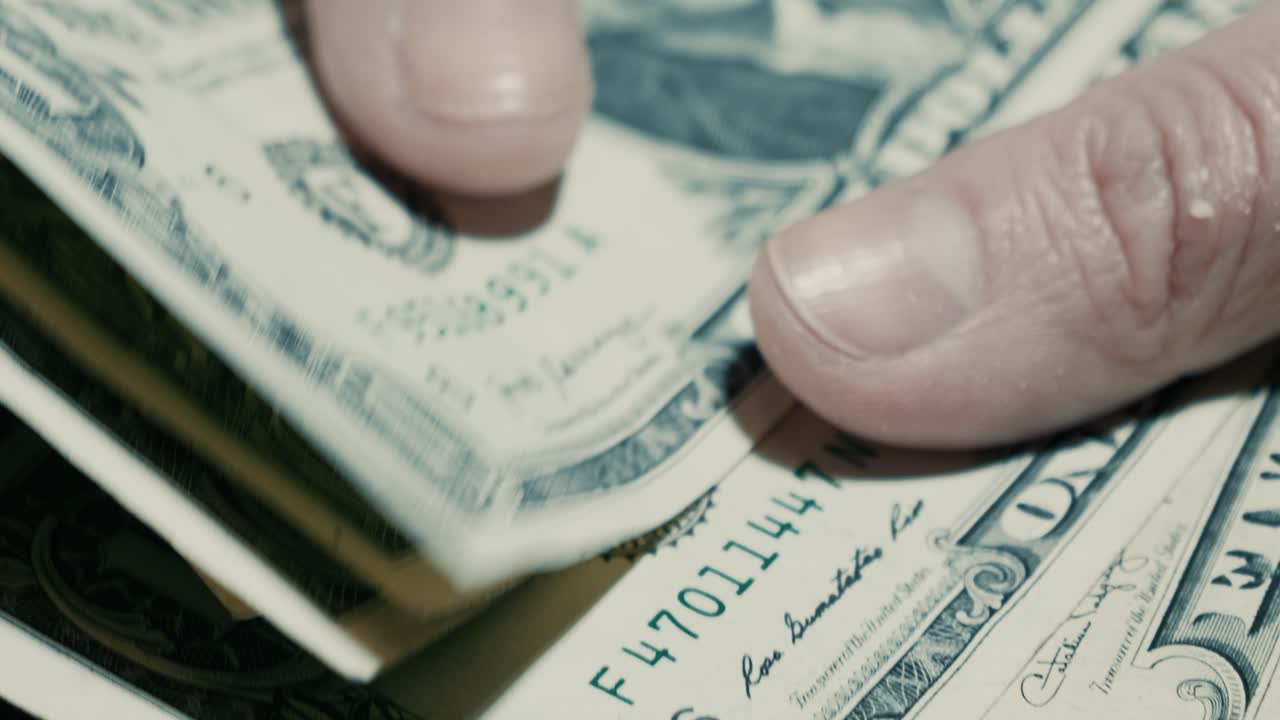 Close Up of Hands Counting and Folding US Dollar Bills