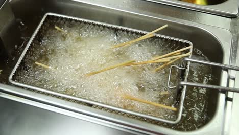 food being deep fried in a commercial fryer