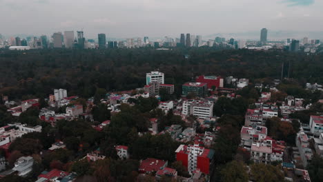 Drone-footage-over-Mexico-City,-flying-towards-the-skyline-and-over-Chapultepec-Park,-showcasing-urban-beauty-and-green-spaces