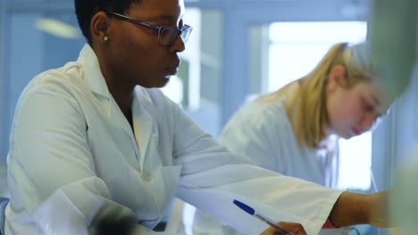 Attentive-female-scientist-experimenting-in-laboratory