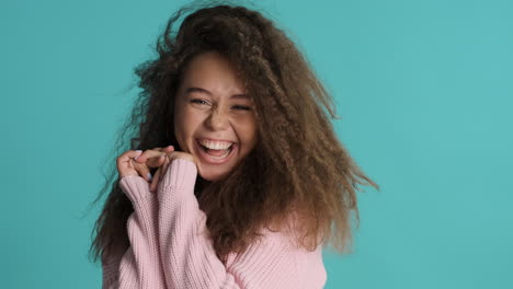 caucasian curly haired woman smiling to the camera.