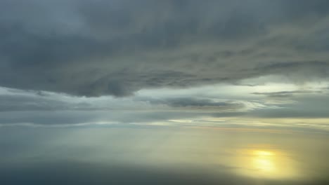 awesome sunset over the mediterranean sea recorded from a jet’s cockpit while flying under a layer of clouds at 7000m high