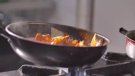 tortilla chips with hot salsa in frying pan on burning fire in slow motion