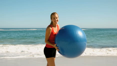 Frau-Spielt-Mit-Ihrem-Fitnessball-Am-Strand-