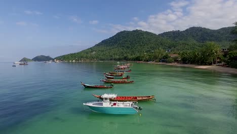 slowly fly over longtail boats on empty beach at koh tao thailand