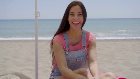 Beautiful-woman-seated-in-shade-at-beach