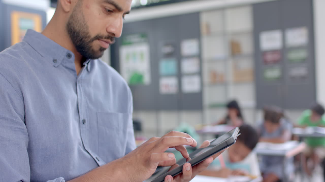 Young Asian man using a tablet in a classroom in school, with copy space