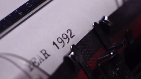 año 1992, escribiendo en papel blanco en una máquina de escribir de época, de cerca