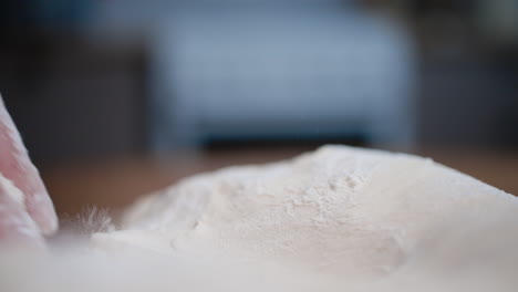 slow-motion close-up of dough as a chef kneads it with flour