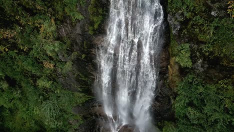 Falling-drone-shot-if-a-waterfall-in-beautiful-nature