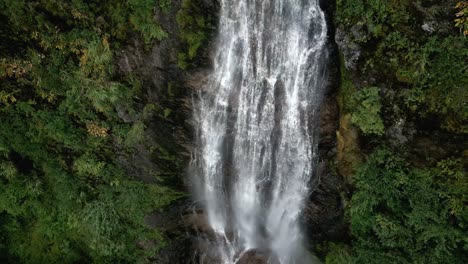 falling drone shot if a waterfall in beautiful nature