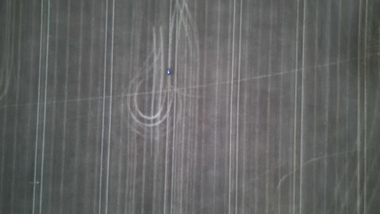 빈 들판에서 오토바이를 따라가는 높은 고도의 드론 샷