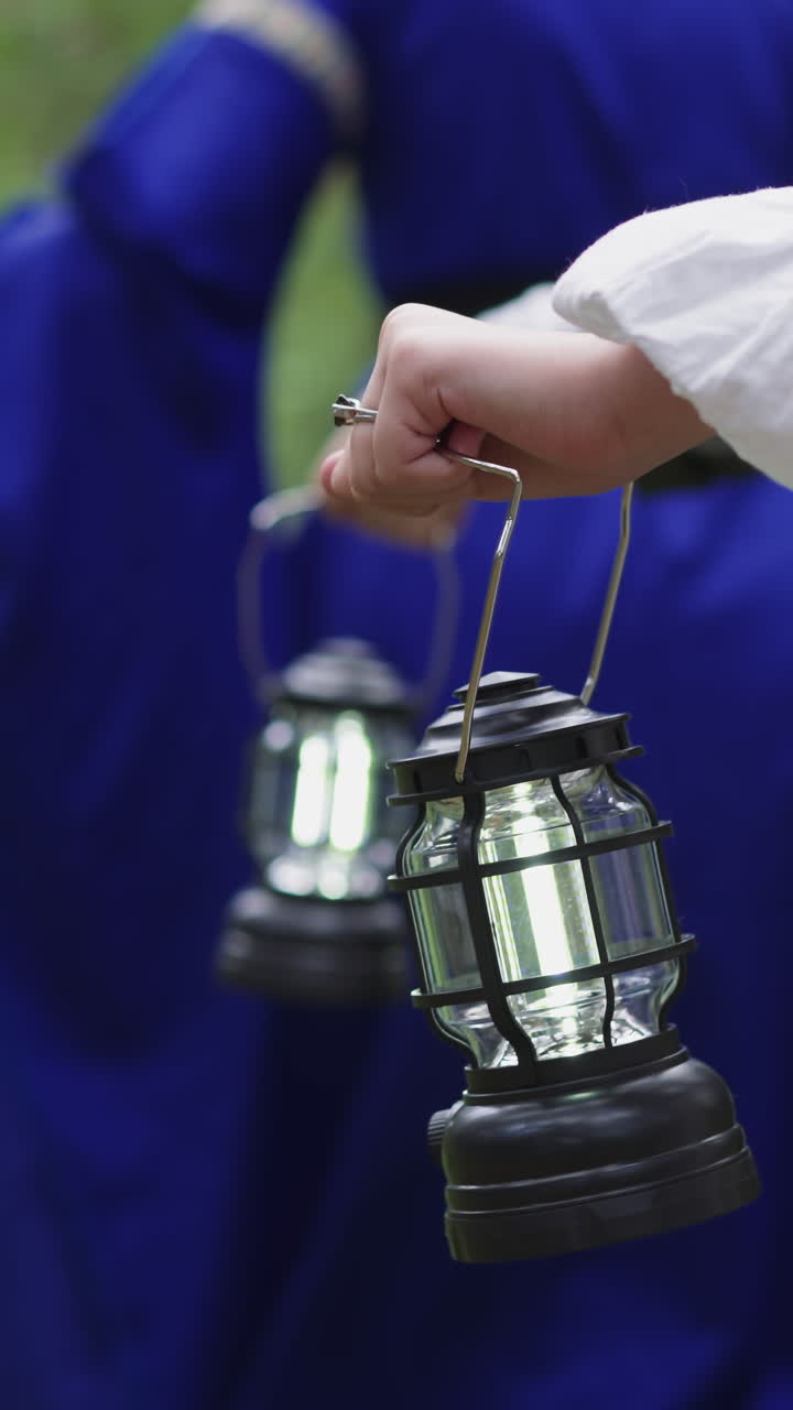 중세 드레스를 입은 한 무리의 여성들이 랜턴을 들고 야생 숲을 고 있습니다. 자연에서 신비로운 의식, 스트에서 롤플레잉.