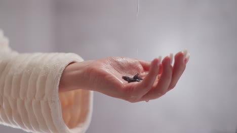 female pours liquid product into hand to apply to hair in shower. flowing moisturizing shampoo drips onto hand in bathroom with blurred background