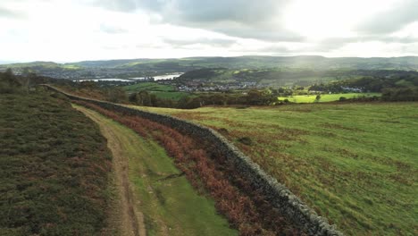 sunbeams moving across overcast british agricultural rural village countryside morning aerial low dolly left view