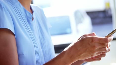 Smiling-businesswoman-using-mobile-phone