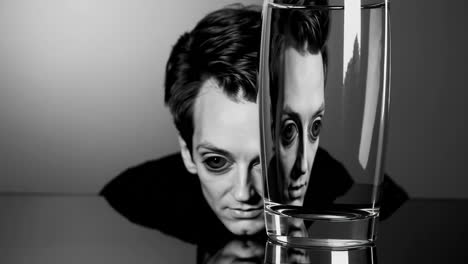distorted reflection of a man through a glass of water