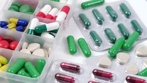 resistencia a los antibióticos, muchas pastillas y cápsulas coloridas, rojas y amarillas, envases con medicamentos