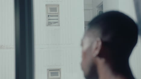 black guy looking through the window at home