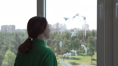 trabajador de la empresa de limpieza o ama de casa limpiando ventanas usando detergente y paño para limpiar ventanas. lavando ventanas con una botella de pulverización.
