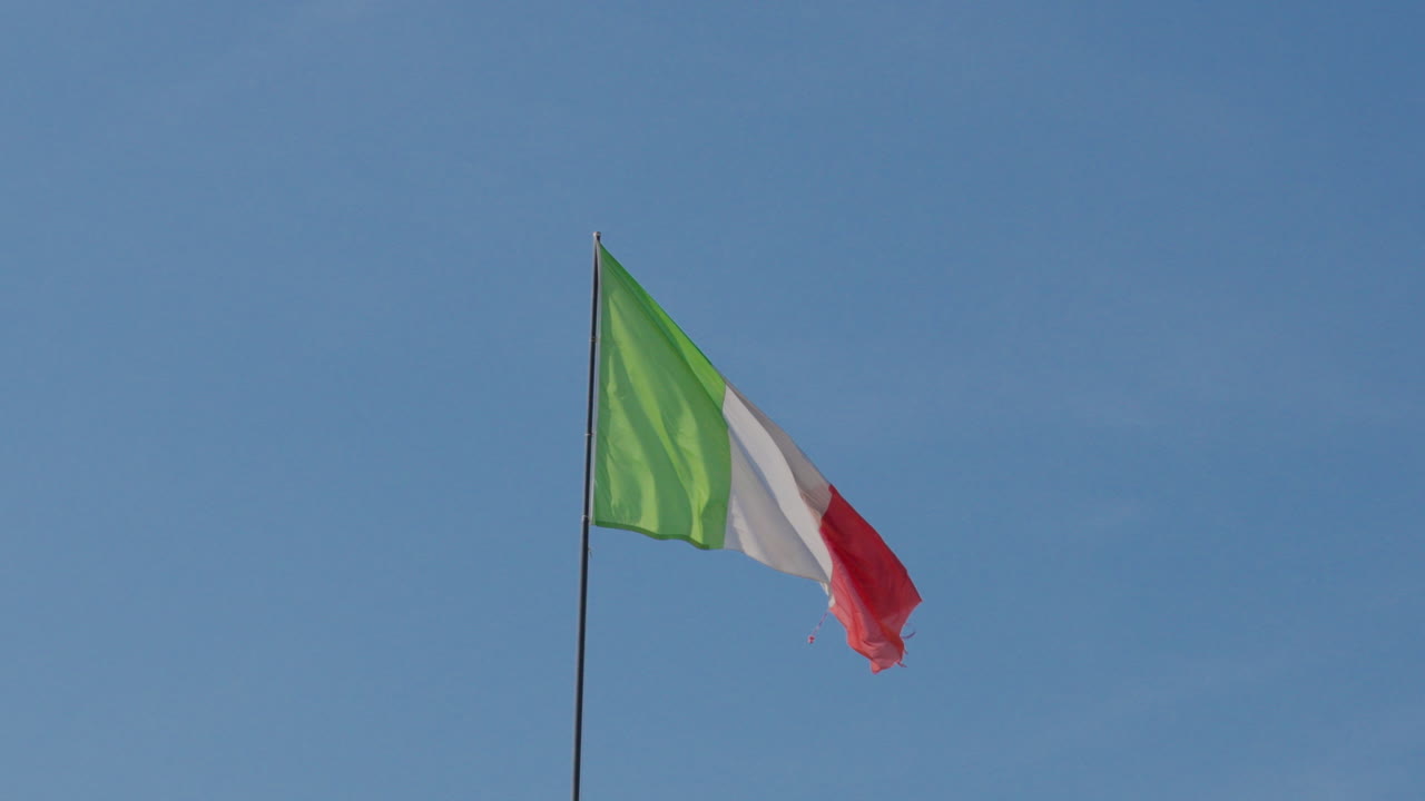 이탈리아 국기가 베로나의 은 파란 하늘을 향해 흔들리고 있습니다.