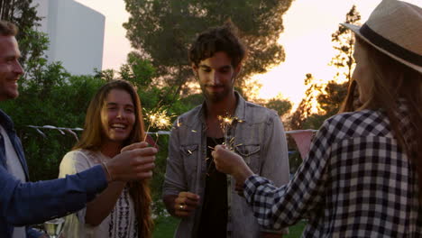 grupo de amigos con chispas disfrutando de una fiesta al aire libre