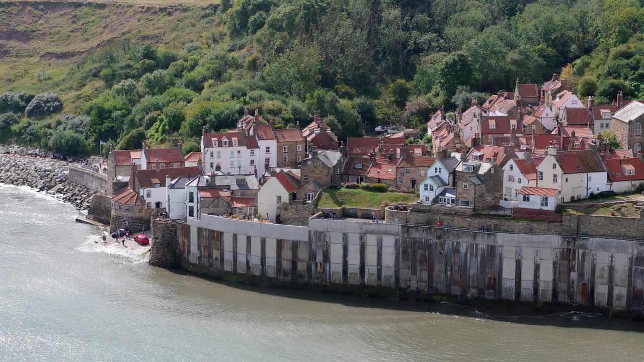 vista aérea de la bahía de robin hood en el norte de yorkshire, sobre el pueblo y las casas que muestran el océano y el encantador pueblo costero