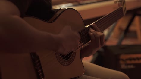 close up shot of male musician playing guitar and keyboard piano in background - band playing indoors