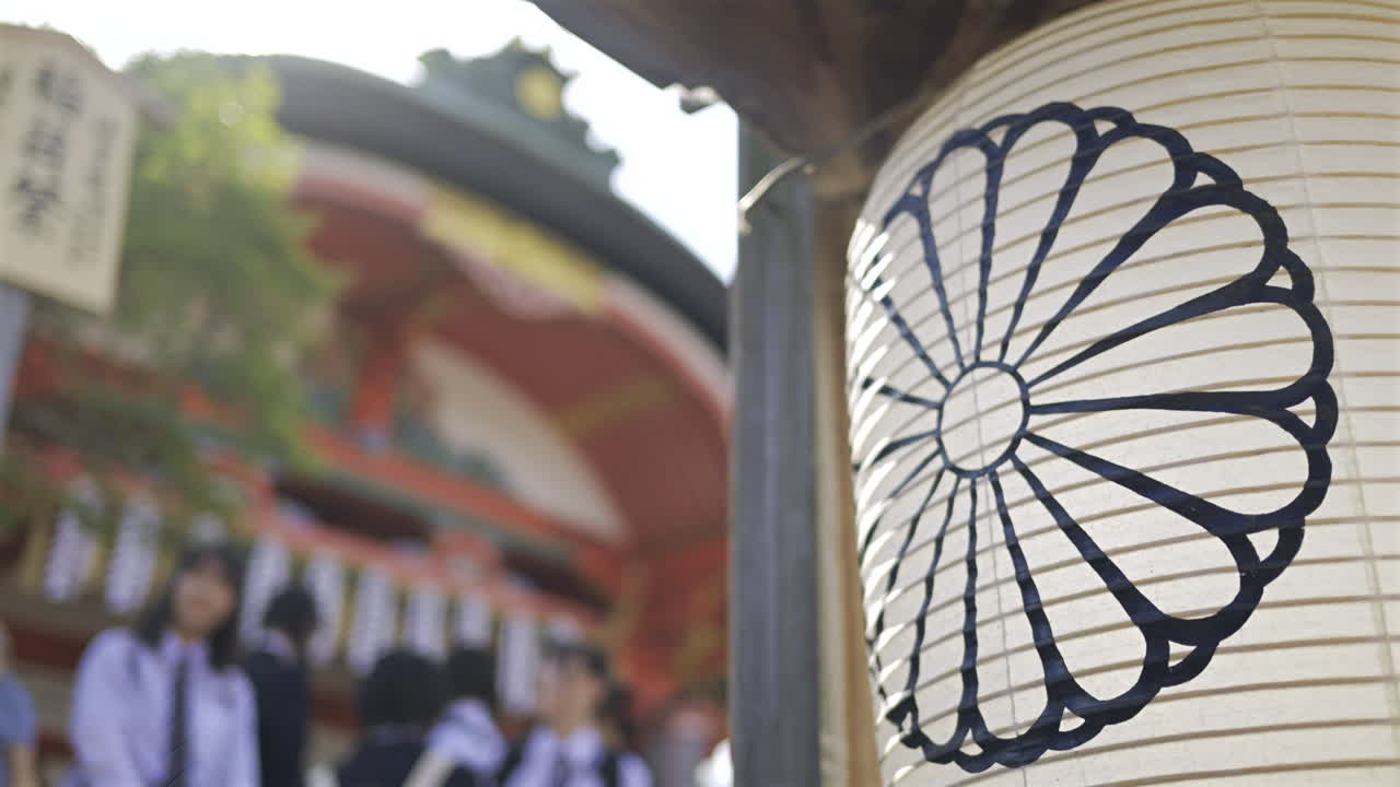 A beautiful lantern hangs in Fushimi Inari traditional shrine in Japan. People walking on background
